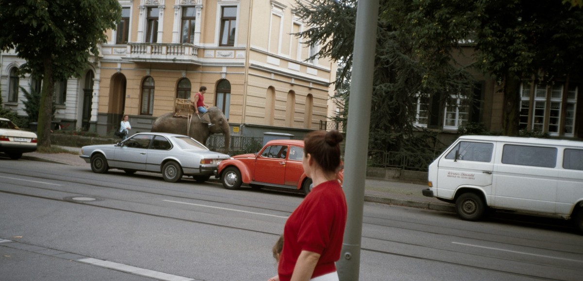 : Süheyla (Ruziye) Kocatürk und ihre Tochter Begüm beobachten einen Elefanten, der vermutlich als Werbung für einen Zirkus durch die Stadt läuft, Krefeld, ca. 1987. Foto: Dengin Kocatürk © Dengin Kocatürk /DOMiD-Archiv, Köln